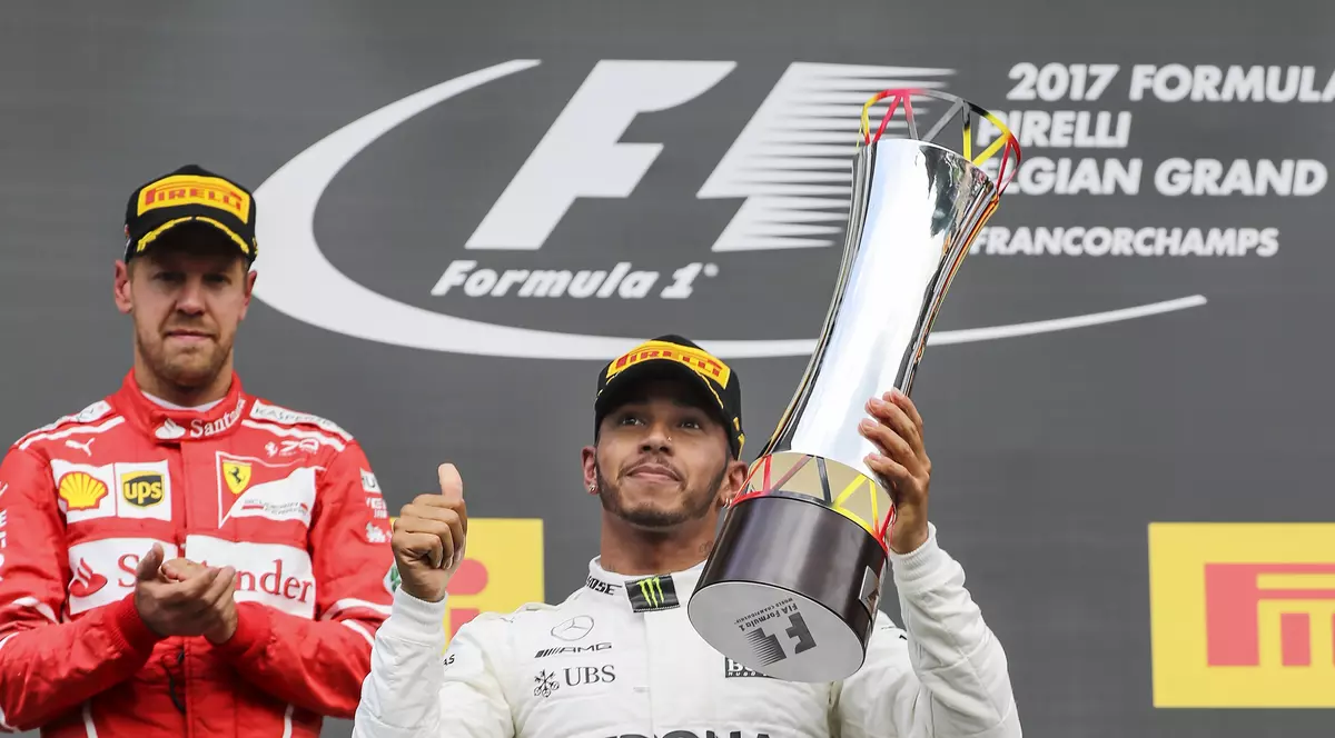 Lewis Hamilton ridică un trofeu deasupra capului, sub privirile lui Sebastian Vettel. (FOTO: EPA)