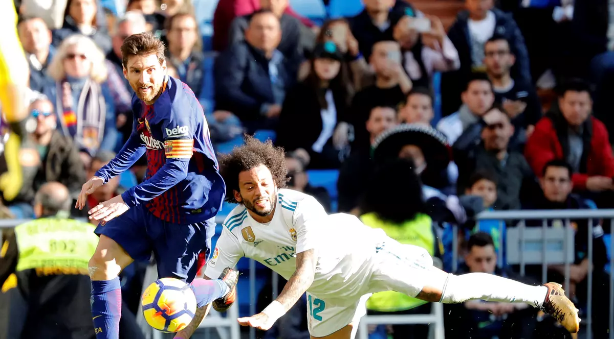 Lionel Messi (stânga), atacantul Barcelonei, trece în dribling de Marcelo, fundașul lui Real Madrid. (FOTO: EPA)