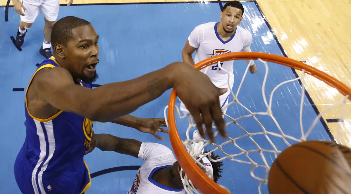 Kevin Durant (în albastru), baschetbalistul lui Golden State Warriors, marcând în timpul unui meci cu Oklahoma City Thunder. (FOTO: EPA)