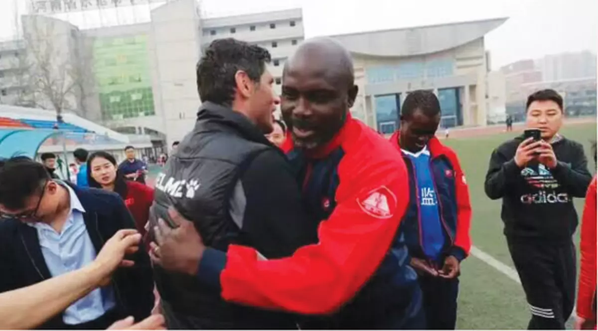 Un antrenor român s-a întâlnit în China cu George Weah. Florin Pârvu (stânga) l-a îmbrățișat pe fostul star de la Milan