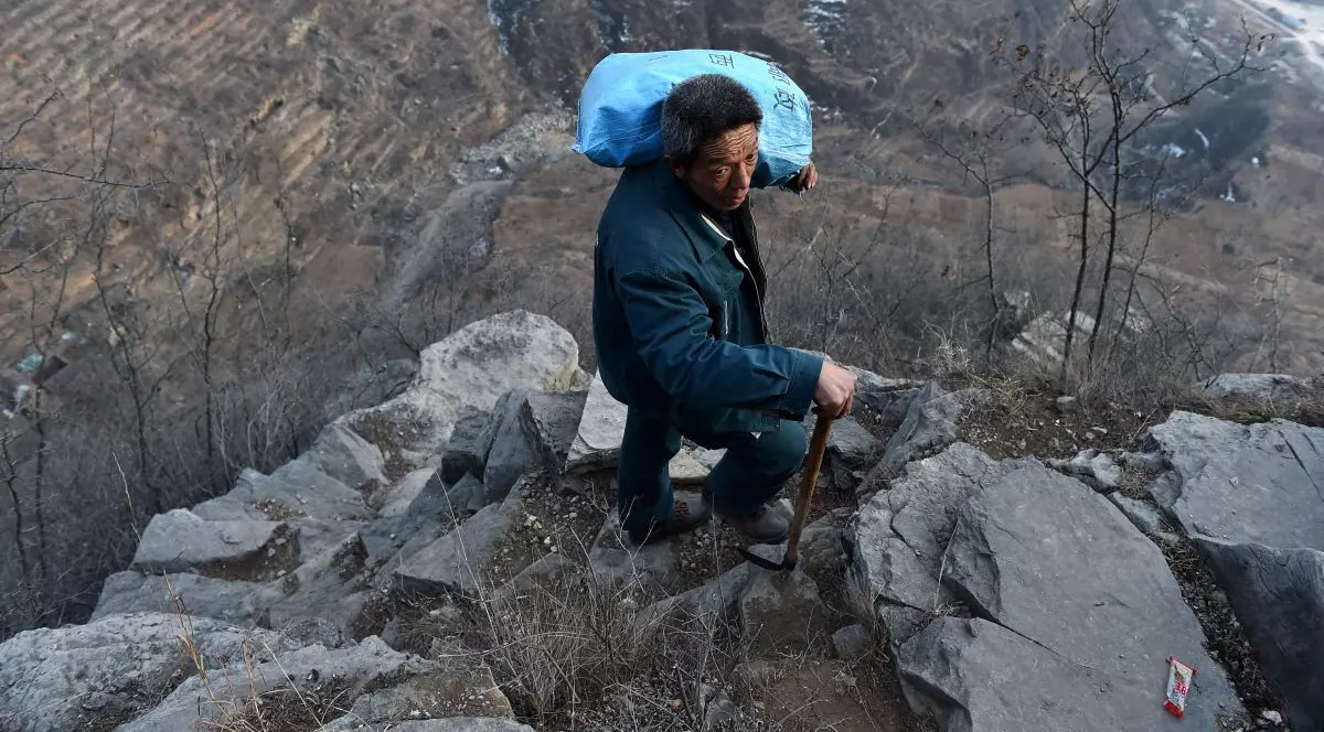 un poștaș din China se cațără zilnic pe drumuri de munte