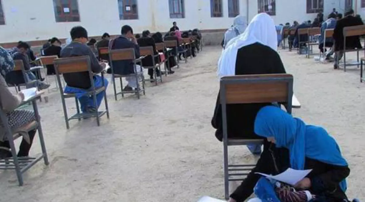 FOTO | Ipostaza care face înconjurul lumii: O tânără afgană are grijă de bebelușul ei în timp ce dă examenul pentru admitere la universitate