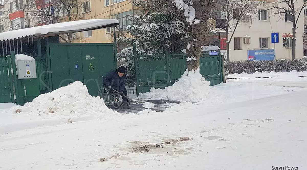 Un bărbat în scaun cu rotile a deszăpezit trotuarul din fața casei în Buzău