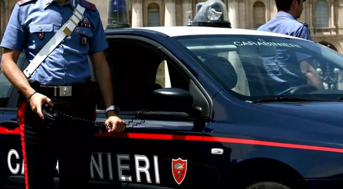 Doi români prinsi la furat in Italia au chemat singuri carabinierii. Un carabinier care se srpijină pe mașina de serviciu