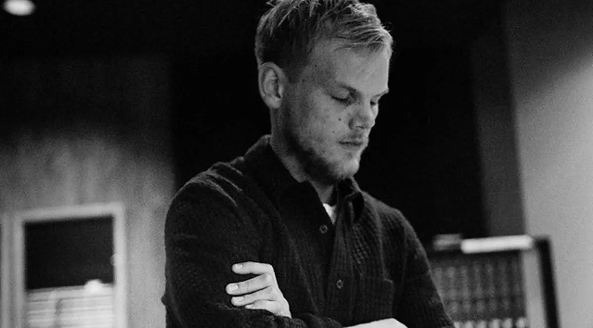 DJ Avicii va fi înmormântat în cadrul unor funeralii private. Foto alb-negru cu DJ Avicii, stând în picioare, în care are ochii închiși și mâinile încrucișate