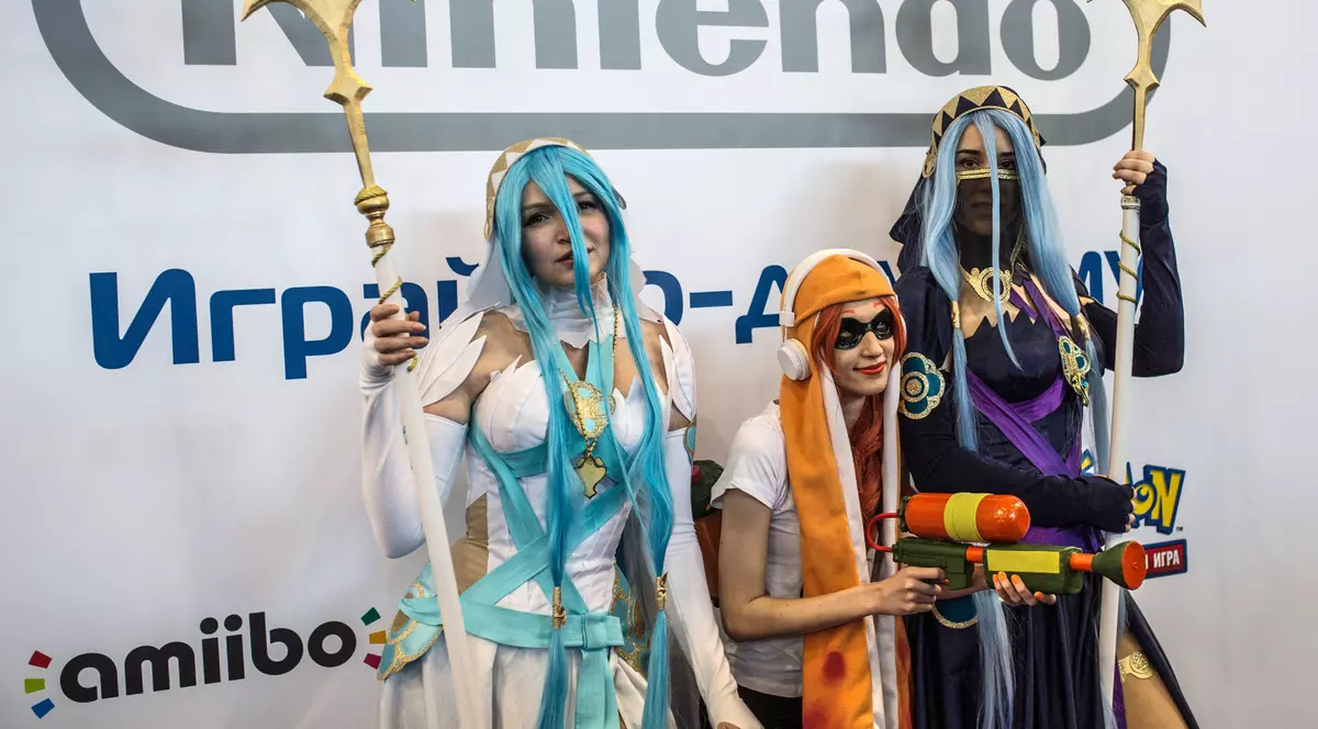 Nintendo a vândut 17,8 milioane de console Switch și estimează un profit de 2 miliarde de dolari. Trei cosplayeri lângă o siglă Nintendo la Comic Con
