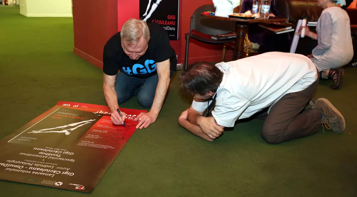 Gigi Căciuleanu a dat autografe desculț, stând în genunchi și a scos la licitație poezii scrise de el