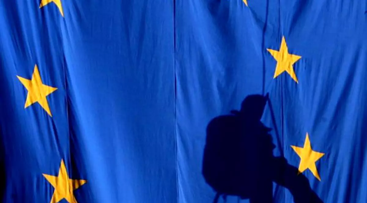 Ce s-a întâmplat azi, 9 mai. Steagul Uniunii Europene (UE), iar pe fundal este umbra unui alpinist utilitar