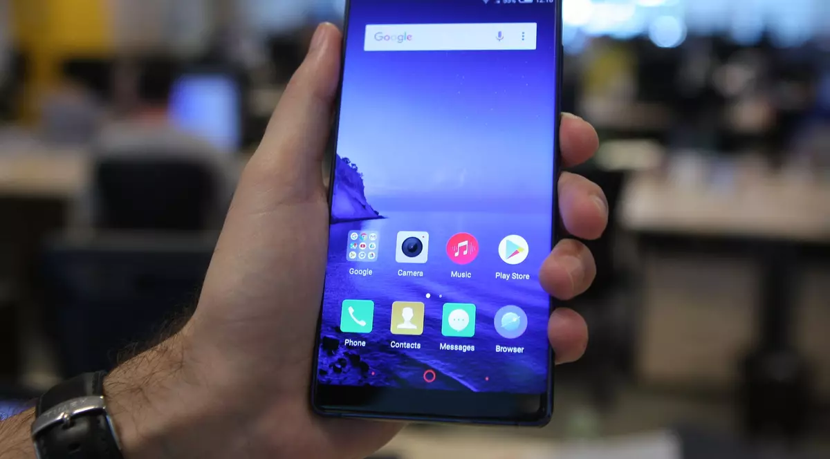 Archos Diamond Omega, un smartphone cu specificații aproape de top, la un preț accesibil. Archos Diamond Omega ținut în mână, cu redacția pe fundal