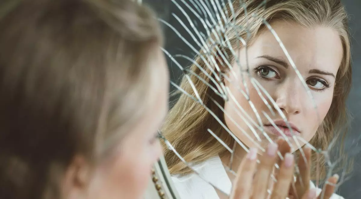 Zilnic, este depistat cel puțin un vasluian cu afecţiuni psihice. Femeie care se uită într-o oglindă spartă