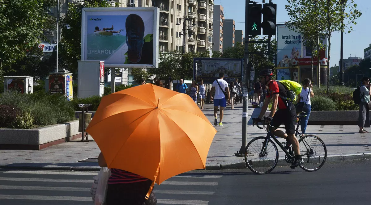 Cum va fi vremea în București, pe 9 iunie. Circulație pe timp de ploaie, în CapitalăTemperaturi de vară, în weekend-ul 27-28 octombrie. Femeie cu o umbrelă portocalie, apărându-se de soarele puternic