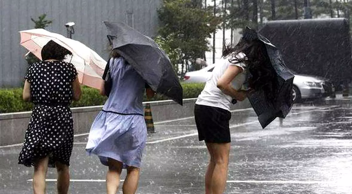 Cod galben de ploi abundente în Brașov și alte trei judeţe. Trei femei cu umbrele stricate din cauza vântului