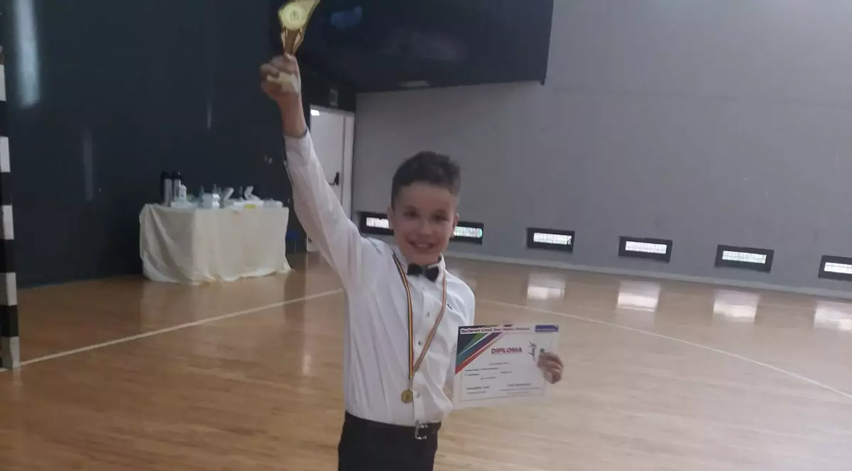 Băiețel de 11 ani care trebuie operat la inima. Remus Grigorescu, după o competiție de dansuri, ținând o cupă în mână