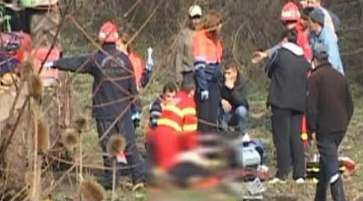 Un bărbat din Buzău a murit, după ce s-a agăţat de remorca unui tractor. Fotografie blurată, cu victima accidentului din județul Buzău. Lângă el se află și medicii, care nu au mai putut face nimic pentru el