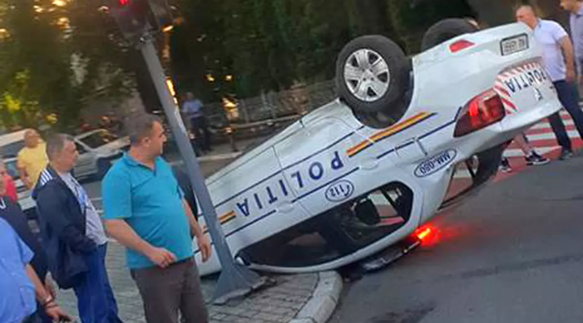 O mașină de Poliție s-a răsturnat în fața secției, în Baia Mare. Agentul a trecut pe roșu și a făcut accident