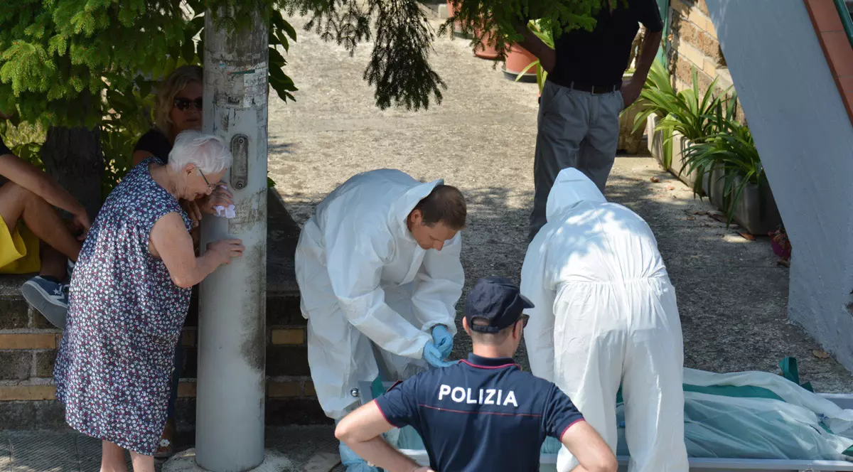 O româncă a fost găsită moartă în Italia, în locuința bătrânei pe care o îngrijea. Imagine cu criminaliștii care ridică cadavrul