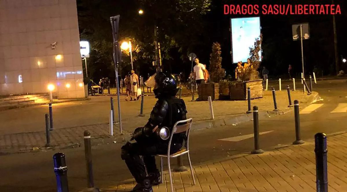 Povestea din spatele fotografiei virale cu jandarmul care stă pe un scaun, după intervenția din Piața Victoriei. Cum a fost realizată ”Cumințenia pământului”