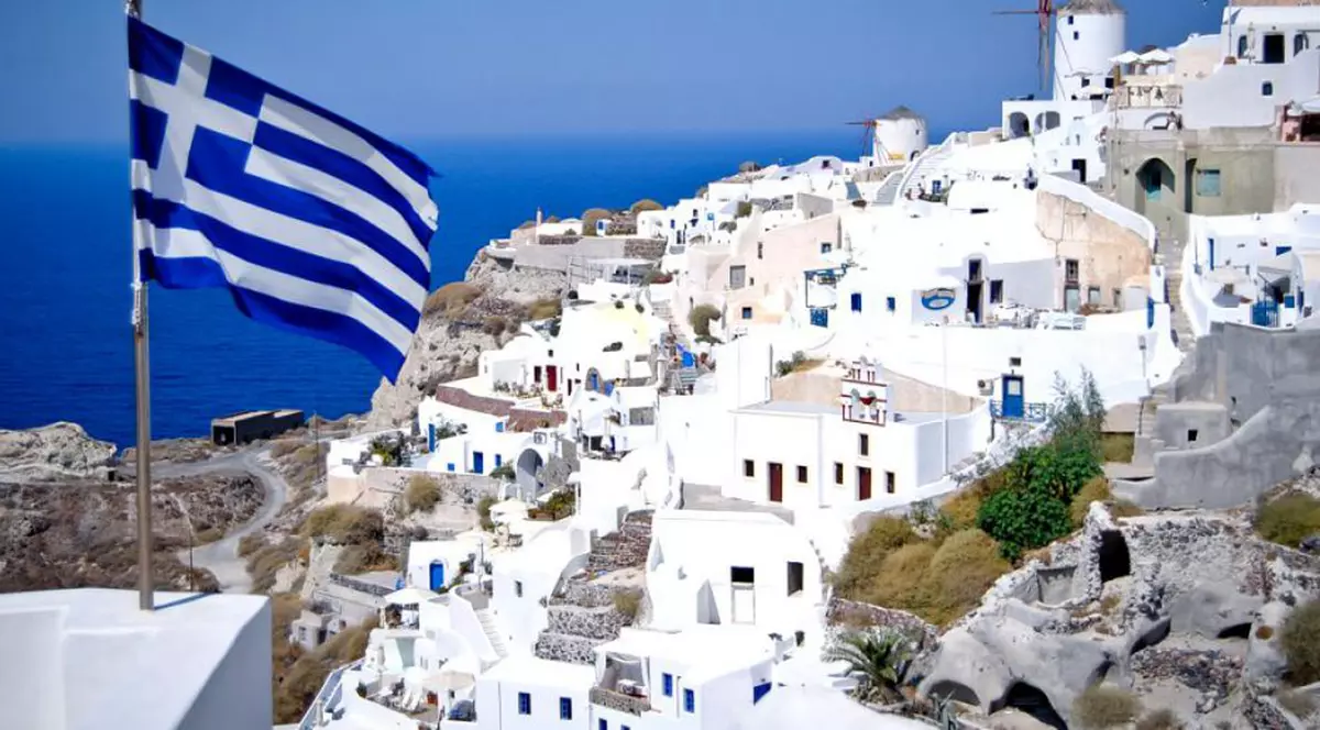 Majorări salariale în Grecia. Peisaj din Grecia, cu un drapel al acestei țări fluturând