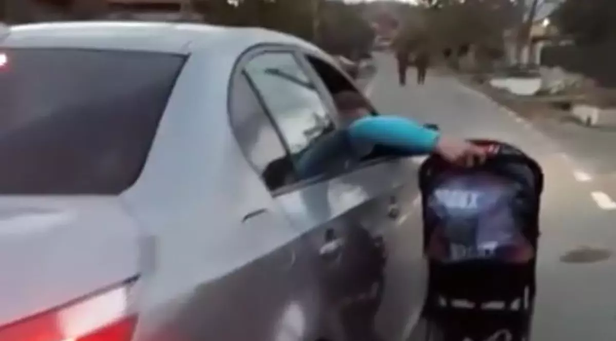 Un bebeluș a fost plimbat de tatăl lui pe lângă maşină, în mers