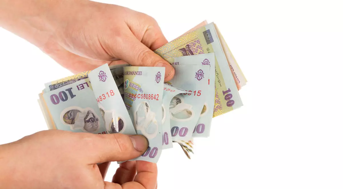 A doua rectificare bugetară din 2018. Bancnote românești, în mâna unui om