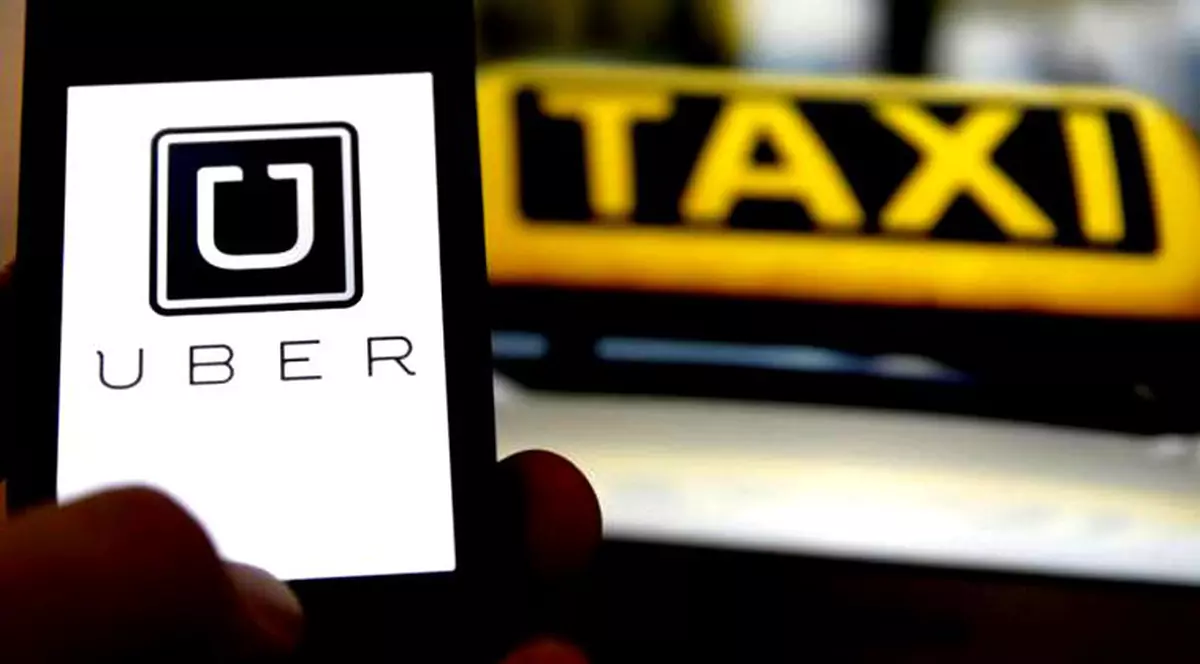 Transportatorii solicită retragerea proiectului de ordonanță de urgență prin care serviciile Uber, Bolt și Clever ar urma să reintre în legalitate. Smartphone cu aplicația Uber deschisă și un taxi pe fundal