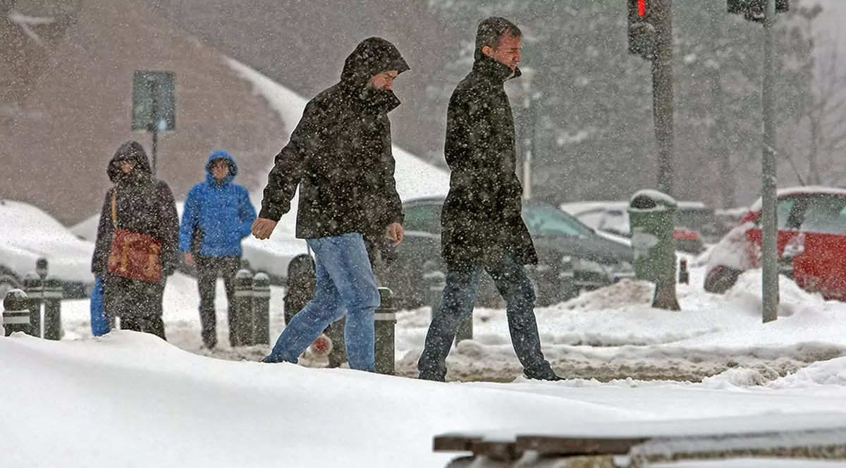 Avertizare meteo pentru Capitală, în următoarele 24 de ore. Oameni mergând prin ninsoare