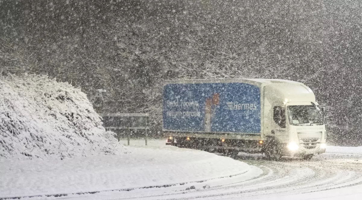 Atenționare meteo de ninsori, până pe 18 decembrie. Camion, într-o curbă, mergând prin ninsoare