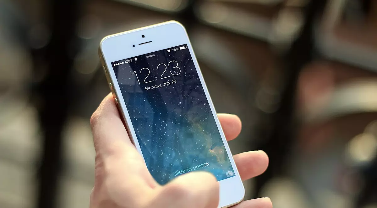 Apple vrea să lanseze un ”Netflix pentru știri”. iPhone 8 alb, ținut în mână