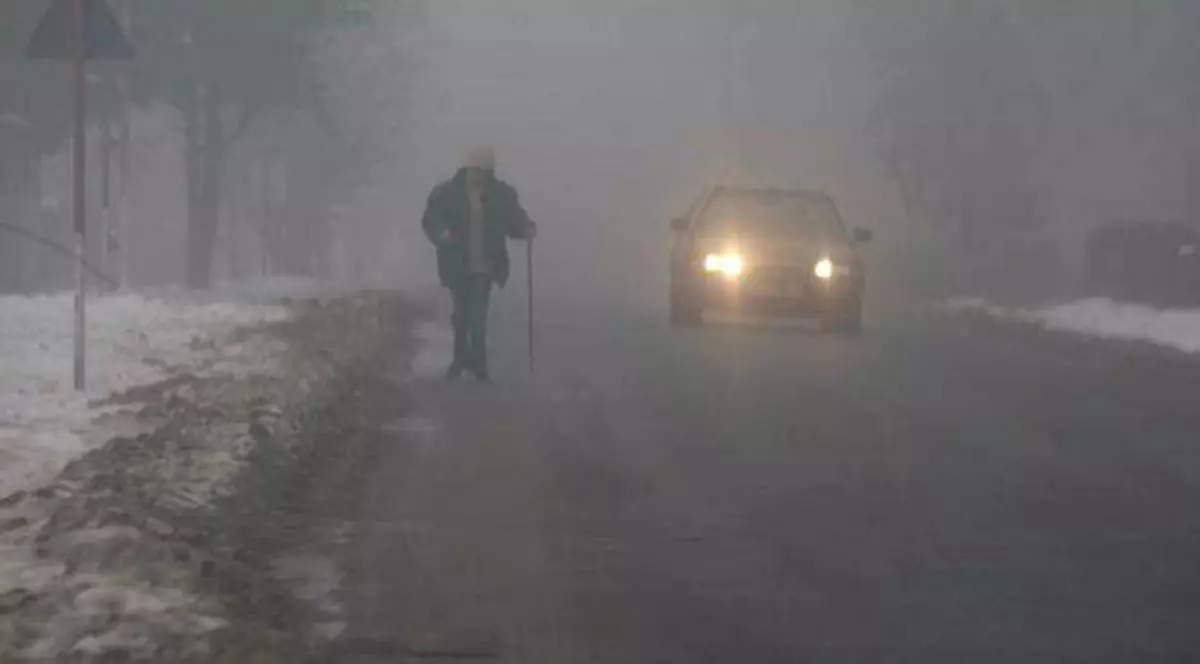 Cod galben de ceaţă în Ilfov și alte 16 judeţe. Un pieton și o mașină circulând prin ceață