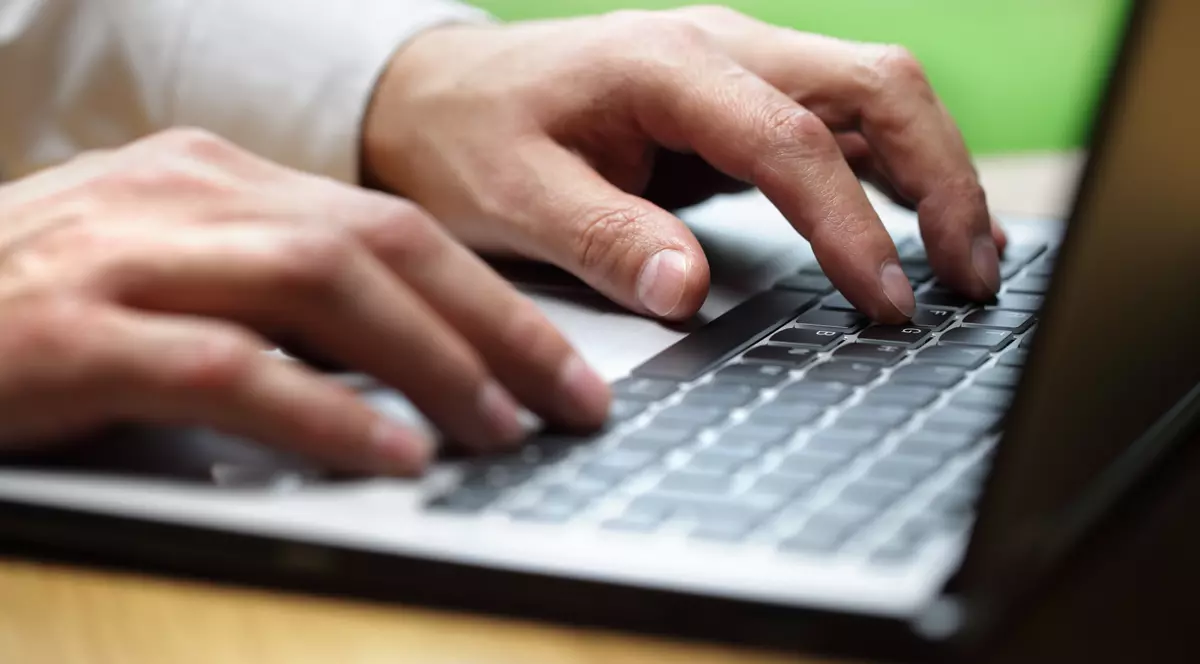 Programatorii se pot trezi cu salariile diminuate cu 6%. Bărbat care tastează la un laptop