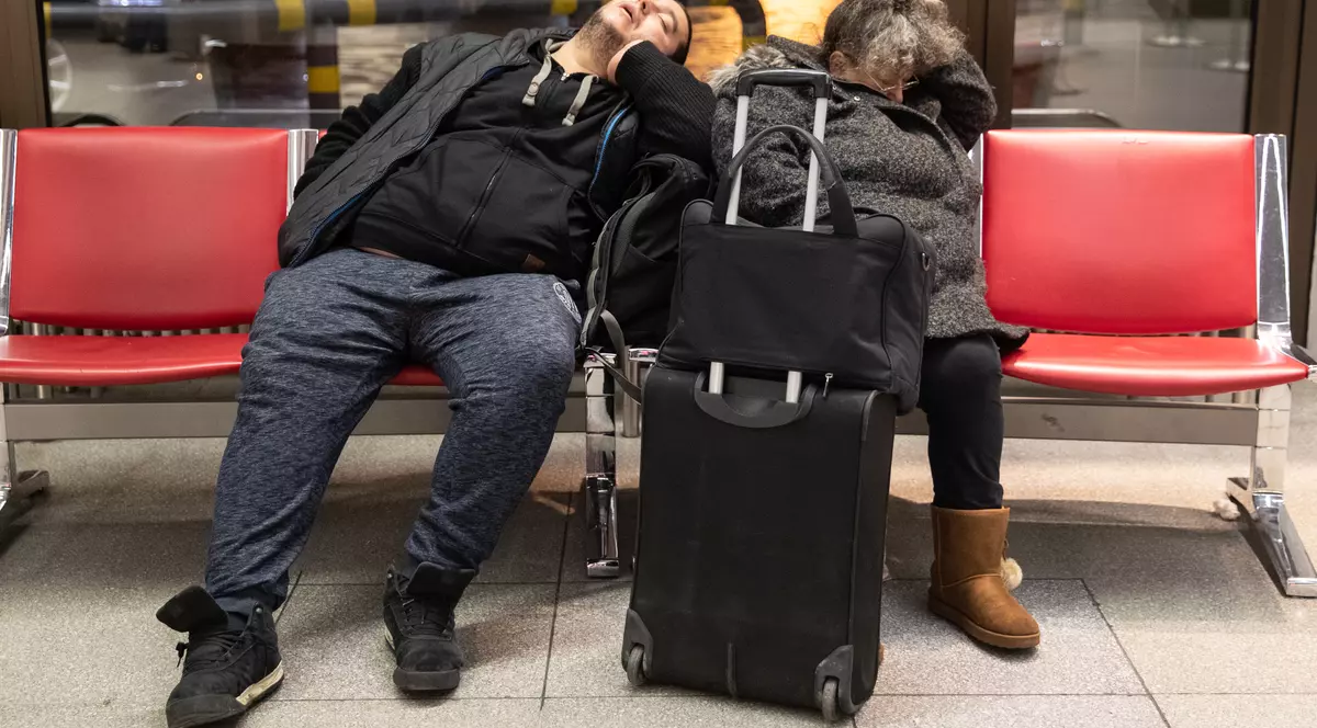 Grevă pe aeroporturile din Berlin. Doi pasageri care dorm pe scaunele unui aeroport din Berlin