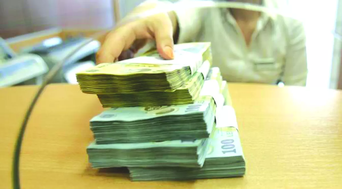 Amânarea ratelor vine la pachet cu raportarea la Biroul de Credit. Băncile spun că nu e motiv de îngrijorare. Teancuri de bani la un ghișeu bancar