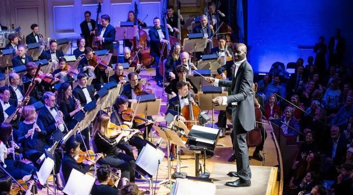 Tacko Fall, dirijor la concertul de Crăciun din Boston. Baschetbalistul de 2,29 metri a făcut show