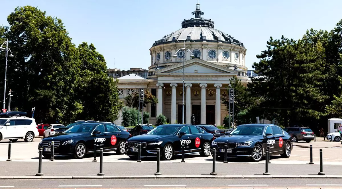 Astăzi intră în vigoare noua lege privind transportul alternativ. Șoferii Uber, Bolt, Yango sau Free Now trebuie să respecte mai multe condiții. Mașini Yango în fața Ateneului Român