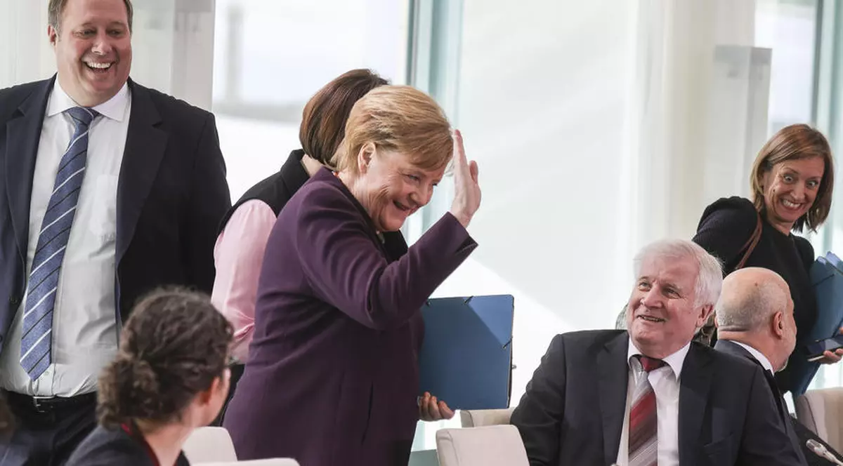 Angela Merkel i-a întins mâna ministrului de Interne, însă acesta a refuzat să i-o strângă. Foto: EPA