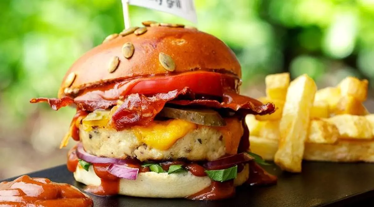 Patron de restaurante: vânzările au scăzut cu 90%, 10% sunt comenzi online. Burger cu steguleț înfipt în el, având sigla City Grill