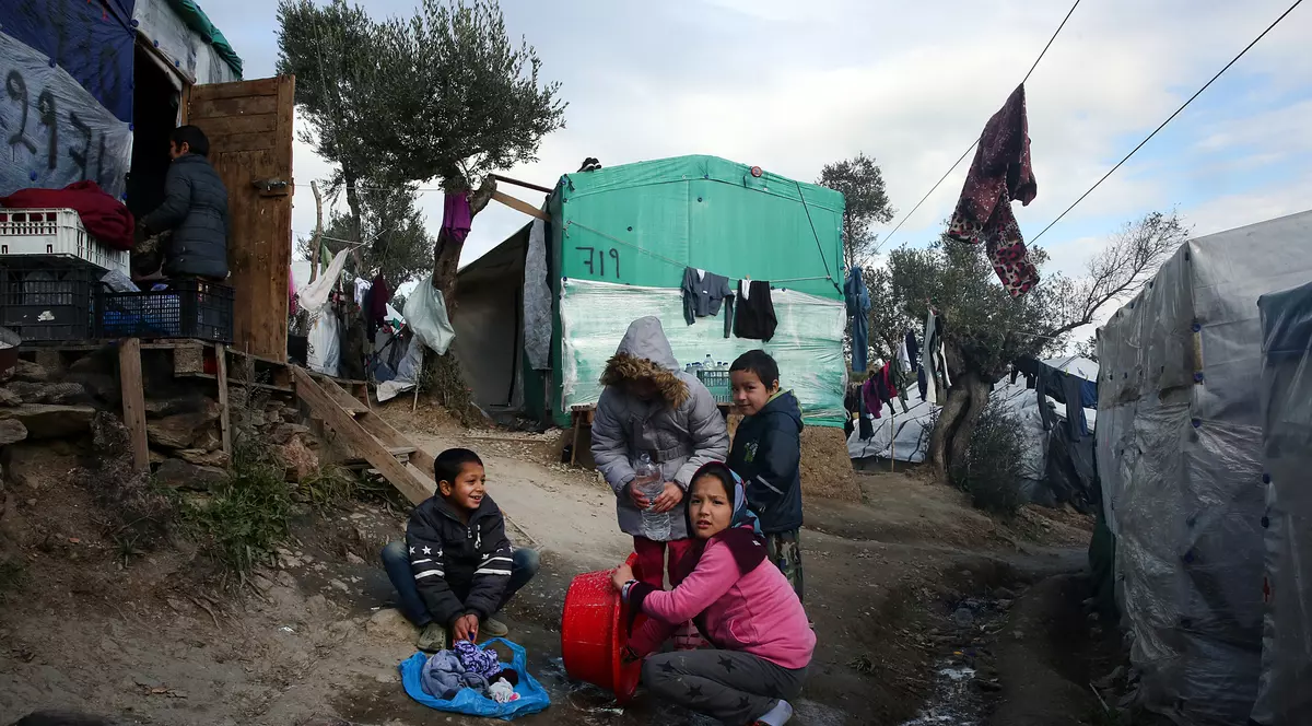 Câțiva copii spală rufe în tabăra de refugiați Moria. FOTO: EPA