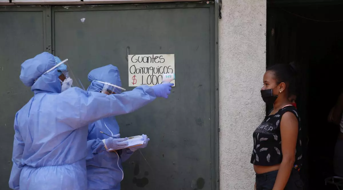 Un cadru medical măsoară temperatura unei tinere din Cali, Columbia FOTO: EPA