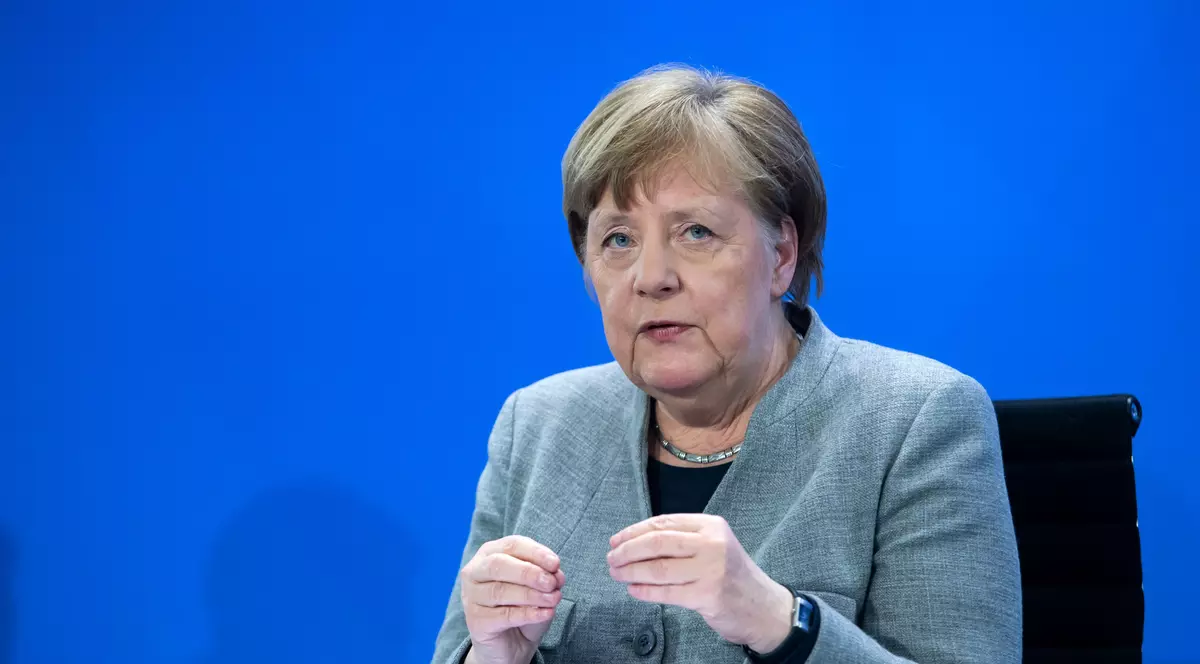 Germania a agreat un plan de relansare economică de 130 de miliarde de euro. TVA-ul scade, cresc subvențiile pentru copii. Merkel la un birou, cu un fundal albastru în spate