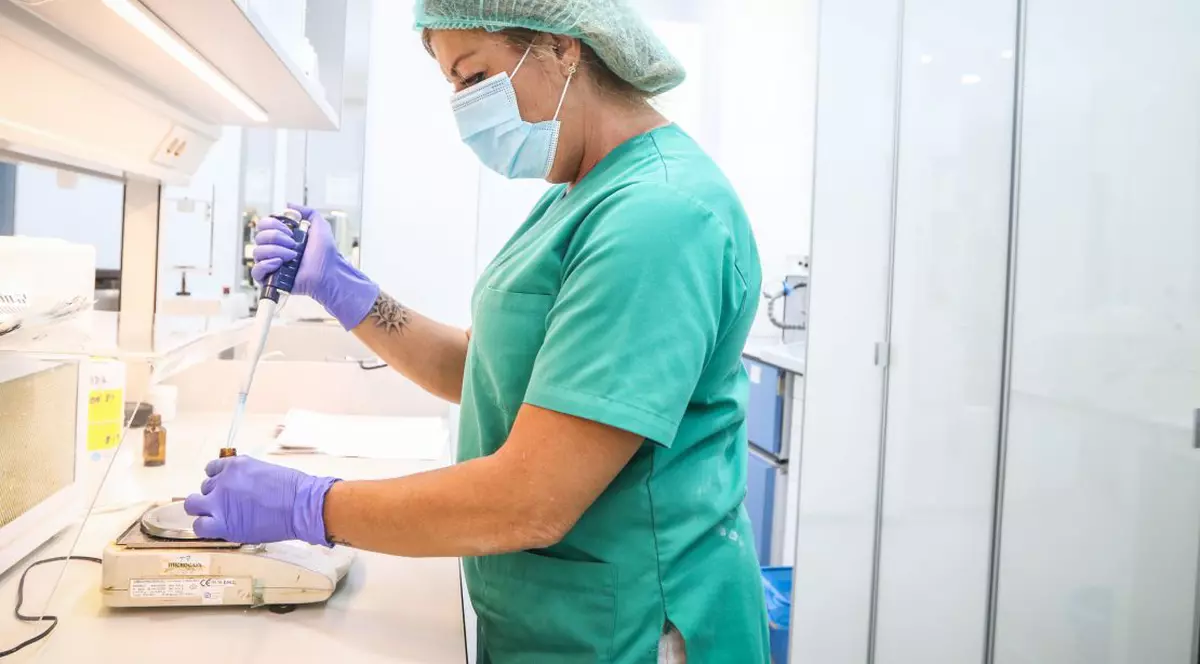 Redeschiderea economiei după coronavirus. Ce ne învață gripa spaniolă din 1918 despre al doilea val. Doctoriță îmbrăcată în verde, cu eprubete într-un laborator