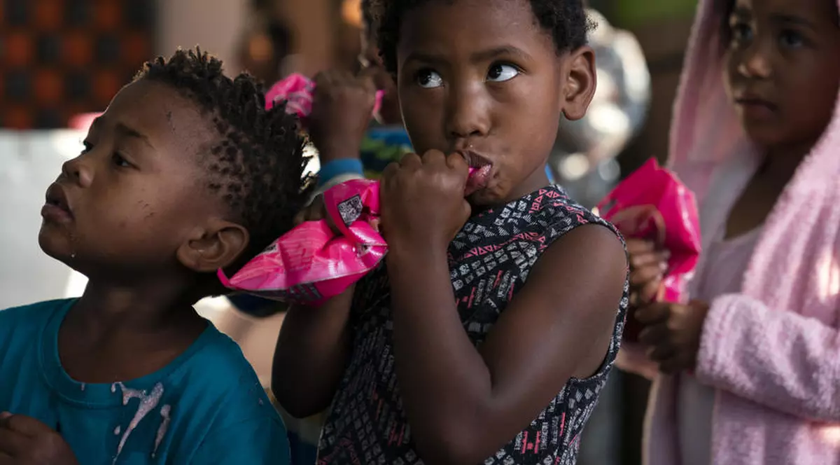 Copii din Africa de Sud, așteptând să primească un pachet de mâncare de la o asociație care se ocupă cu salvarea celor mici de la subnutriție.