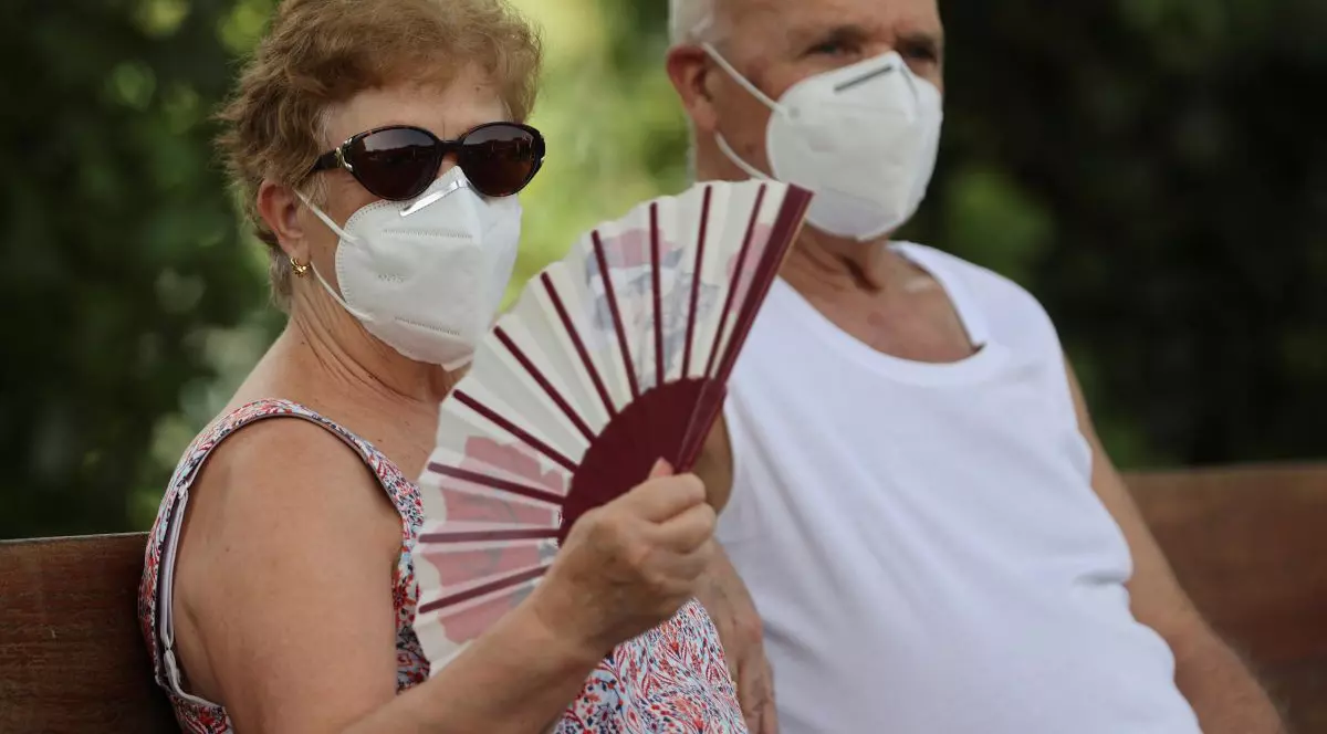 Cu mască și evantai, în căldura din Madrid