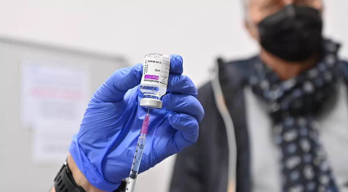 Irlanda dublează capacitatea sistemului de Ambulanță pentru a vaccina oameni acasă. Doctor ce extrage vaccinul din fiolă și o persoană în vârstă în fundal