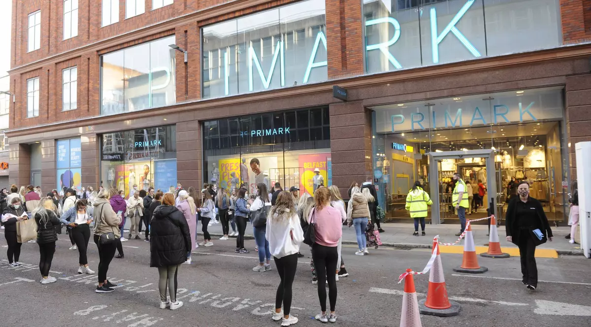 Retailerul de modă Primark vine în România. Oameni la coadă în fața unui magazin Primark, respectând distanțarea fizică