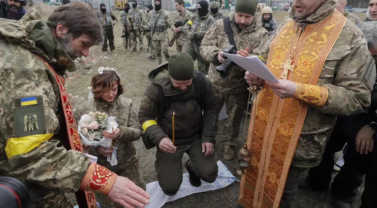 Nuntă pe front. În haine de camuflaj, cu alai înarmat cu flori și puști, doi militari ucraineni s-au căsătorit