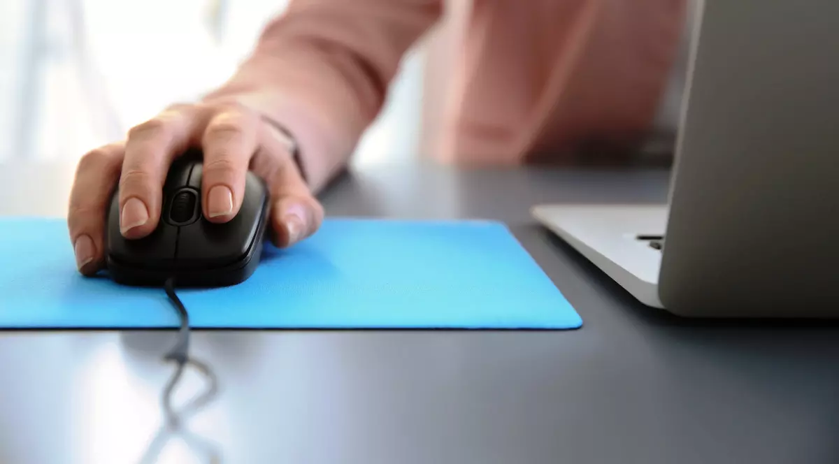 mouse de computer- un mouse pe care sta o mana de barbat