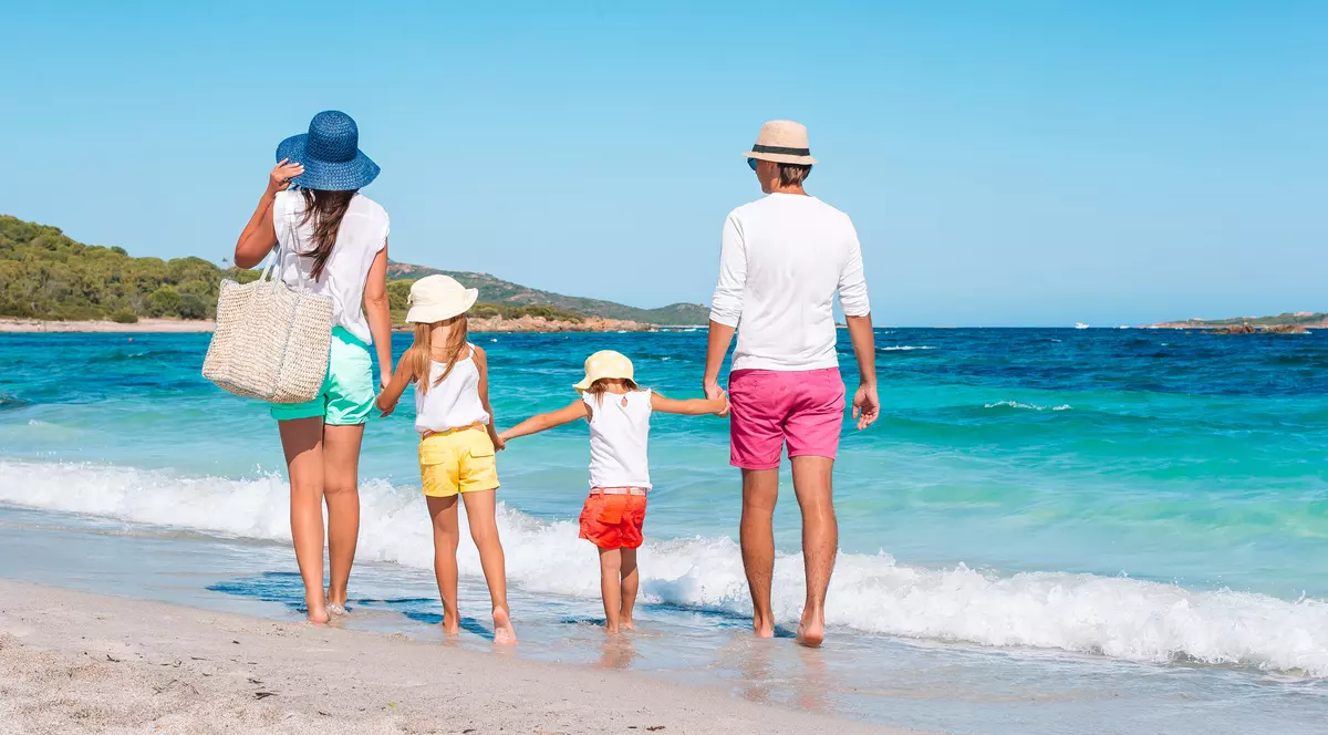 Beneficii vacante. O familie fericita, la plimbare pe plaja