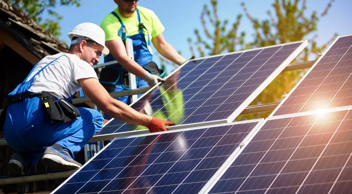 Producere energie electrica- doi tineri monteaza panouri solare