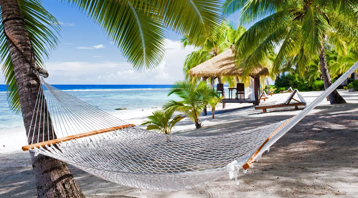 Top 5 hamace suspendate sub 500 de lei - Peisaj de plajă caraibian având în prim-plan un hamac