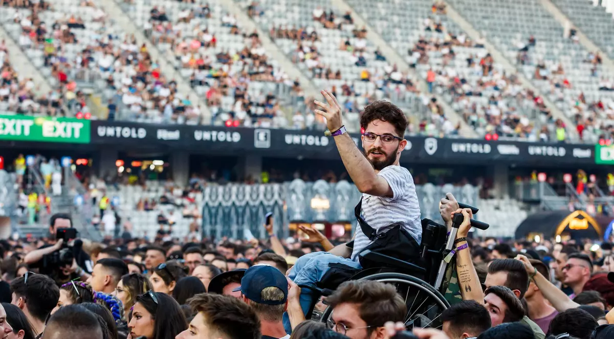 Fotografia zilei la UNTOLD. Tânăr în scaun cu rotile, ridicat deasupra mulțimii, în timpul concertului INNEI